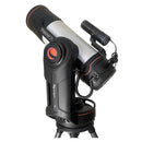 A white and black telescope with orange details, attached to a motorized mount, on a tripod.