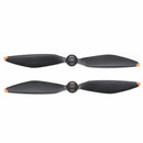 Pair of black DJI Mavic 4 Pro drone propellers with orange tips, designed for aerodynamic efficiency and low noise.