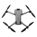 Top view of DJI Mini 5 Pro drone with four black propellers and gray body in folded position