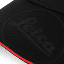 Close-up of black Leica Cap Logo embossed on textured fabric with red trim edge