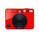Red Leica Sofort 2 instant hybrid camera with modern design and large lens on white background