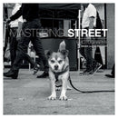 Cover of Mastering Street Photography by Brian Lloyd Duckett featuring a black and white image of a dog with people walking in the background