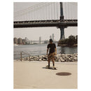 Skateboarder by river under bridge with warm golden tones captured on Lomography LomoChrome film