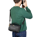 LowePro Adventura SH 160 camera bag worn by man, compact sustainable camera case with shoulder strap for mirrorless cameras and lenses