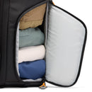 Open Lowepro Fastpack BP 250 AW IV side pocket with neatly folded clothes inside, including blue, white, and beige garments.