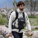 Man hiking outdoors wearing a PGYTECH Camera Top Loader backpack with adjustable straps for versatile carrying options