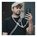 A man with his phone attached via the PGYTECH LinkGo phone strap takes a photo