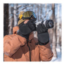 Photographer wearing PGYTech Master Photography Gloves with fold-back fingertips holding camera in snowy forest