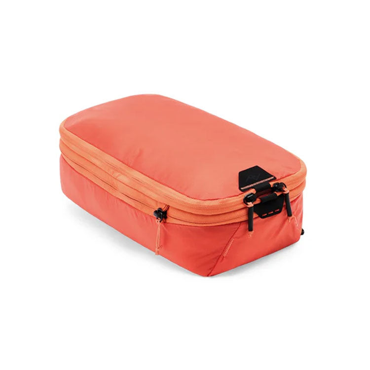 Small Peak Design Packing Cube in coral with tear-away zipper and expandable compartments for organized travel packing