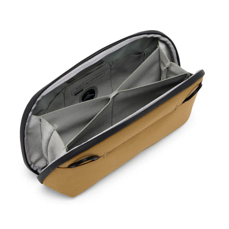 Small Peak Design Tech Pouch in Coyote X-Pac Ocean Edition fabric showing interior compartments for cords and chargers
