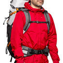 man wearing red jacket carrying LowePro PhotoSport Backpack PRO 55L AW III with harness system on white background