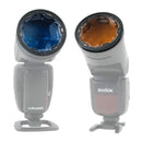 Two camera flashes fitted with Rogue Flash Gel Lenses in blue and orange colors, showing stackable magnetic light modifiers for color correction and portrait gels.