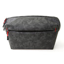 Roots Stealth Crossy compact water-resistant camera sling bag with camouflage pattern and red zipper pulls
