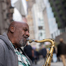 Man playing saxophone on city street captured with Sigma Sport 70-200mm f2.8 DG DN OS lens