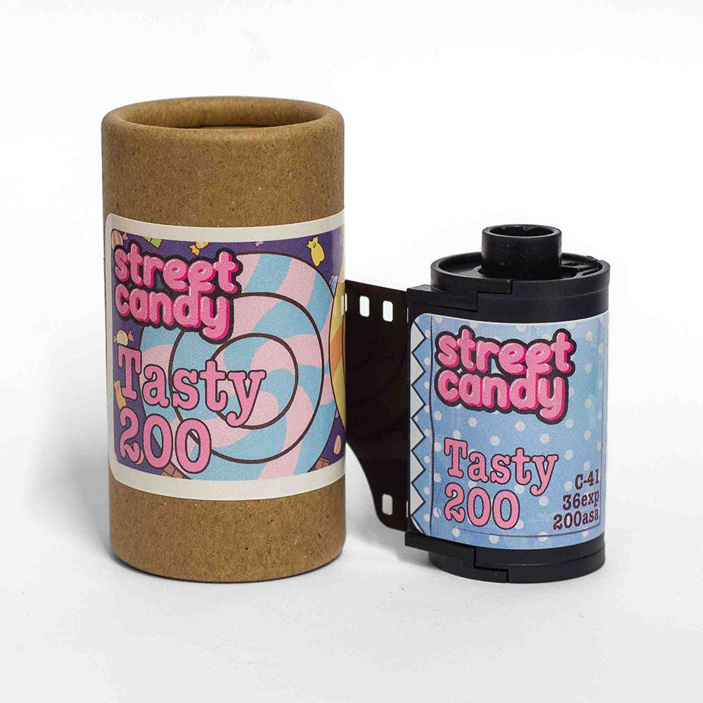 A roll of Street Candy Tasty 200 35mm film beside its cardboard packaging on a white background