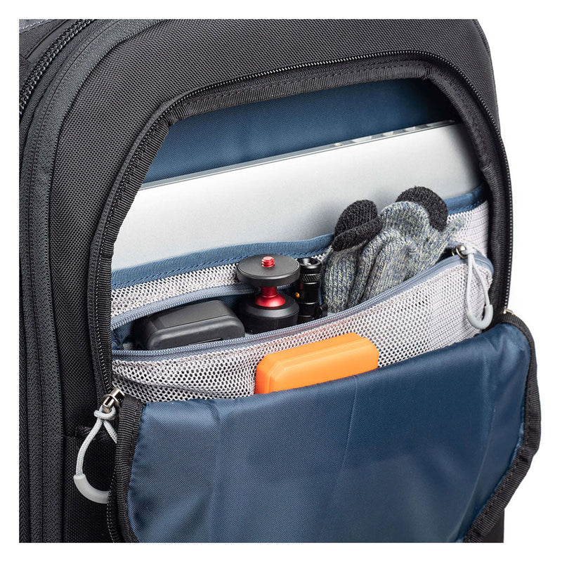 Close-up of ThinkTank FirstLight backpack front pocket with laptop, gloves, camera accessories, and organizer compartments visible