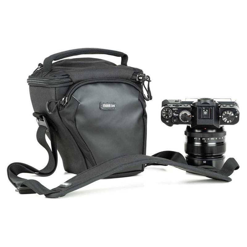 ThinkTank Digital Holster 5 v3 black compact camera bag with shoulder strap and mirrorless camera placed beside it