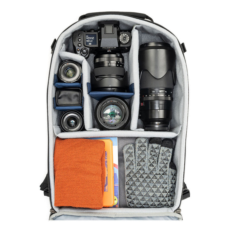Thinktank Mirrorless Mover Backpack open with organized mirrorless camera, lenses, gloves, and accessories in customizable padded dividers