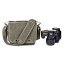 ThinkTank Retrospective 5 shoulder bag in pinestone with adjustable strap next to professional camera and lens