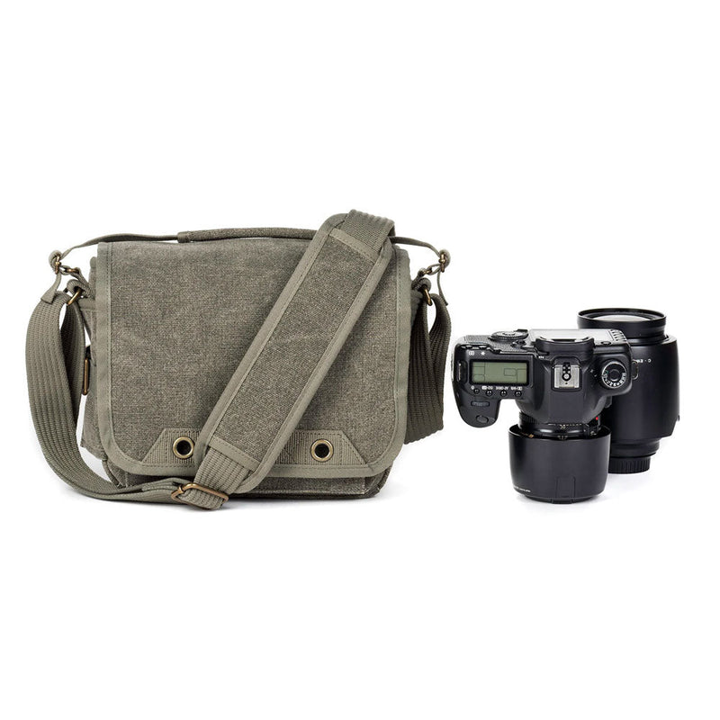 ThinkTank Retrospective 5 shoulder bag in pinestone with adjustable strap next to professional camera and lens