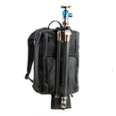 Black backpack with tripod attached on a white background