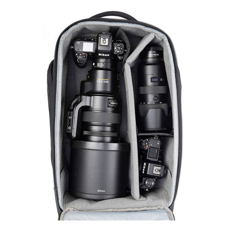 ThinkTank Walker Pro backpack open showing padded compartments with Nikon camera bodies and lenses for professional gear protection and organization