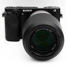 Sony a6000 with silver 55-210mm lens on a white background