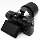 Sony a6000 with silver 55-210mm lens on a white background