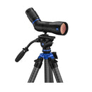 A black, angled spotting scope, mounted to a tripod, on a white background