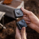 DJI Action 2 camera and magnetic protective case held in hands outdoors