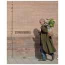 Stephen Waddell street photography showing man walking with flowers and coffee against brick wall background